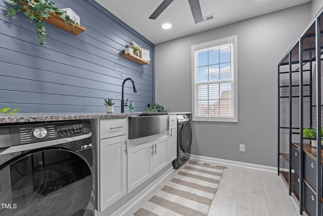 washroom with visible vents, cabinet space, washer / dryer, and light wood-style floors