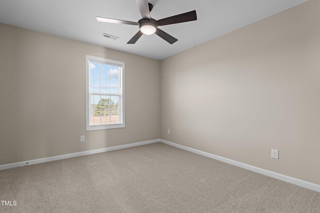 carpeted empty room featuring baseboards, visible vents, and ceiling fan