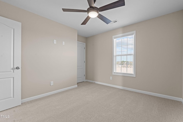 unfurnished room featuring light carpet, baseboards, visible vents, and ceiling fan