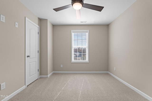 carpeted spare room with visible vents, ceiling fan, and baseboards