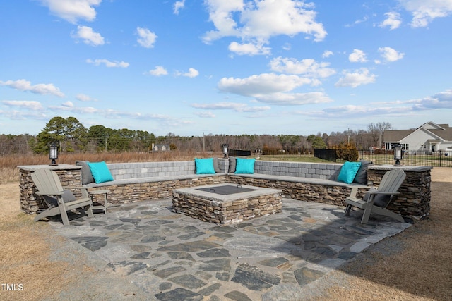 view of patio featuring an outdoor fire pit and fence