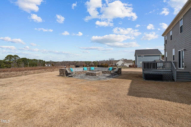 view of yard featuring a patio area, an outdoor fire pit, and a deck