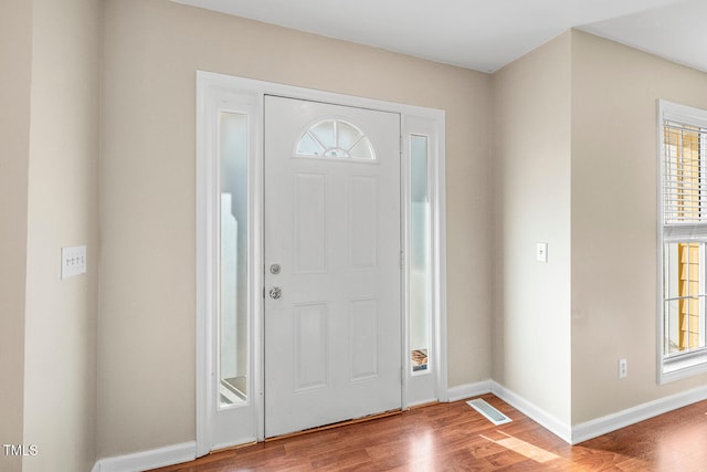 entrance foyer featuring visible vents, baseboards, and wood finished floors