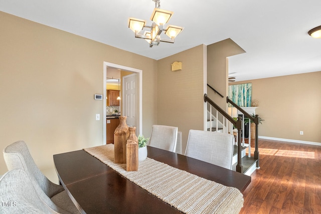 dining area featuring a notable chandelier, stairs, baseboards, and wood finished floors