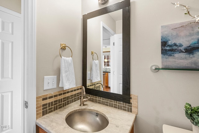 half bathroom featuring decorative backsplash, toilet, and vanity