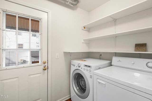 laundry area with laundry area, baseboards, and washer and clothes dryer