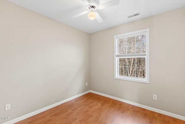 spare room featuring ceiling fan, visible vents, baseboards, and light wood-style flooring