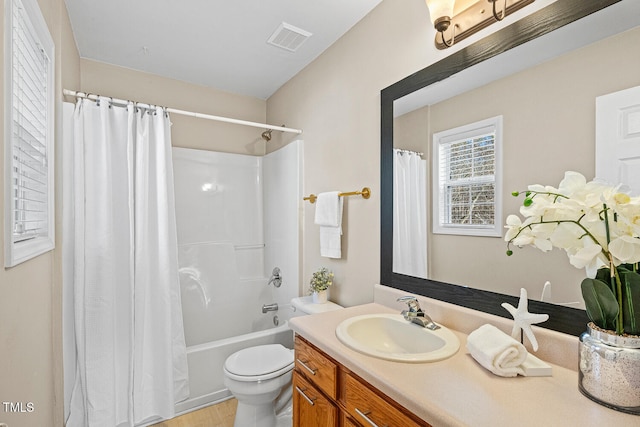 bathroom featuring vanity, toilet, shower / bath combo, and visible vents