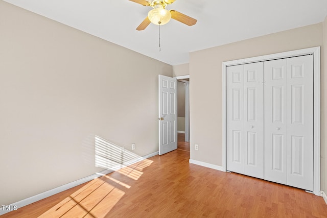 unfurnished bedroom featuring light wood-style flooring, baseboards, a closet, and ceiling fan