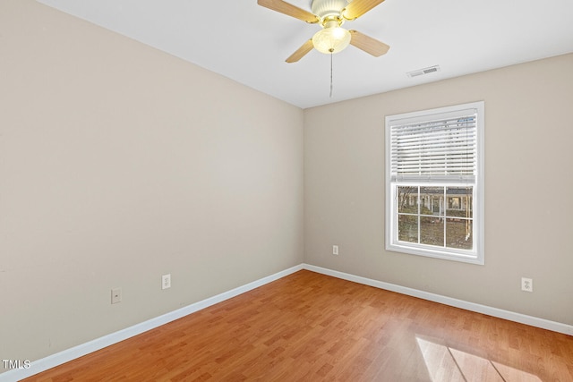 unfurnished room with light wood finished floors, visible vents, a ceiling fan, and baseboards