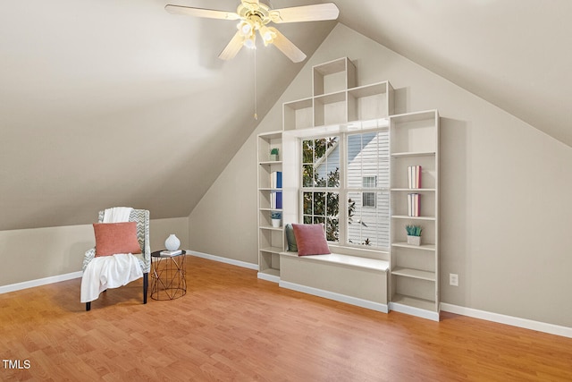 sitting room featuring baseboards, lofted ceiling, wood finished floors, and a ceiling fan