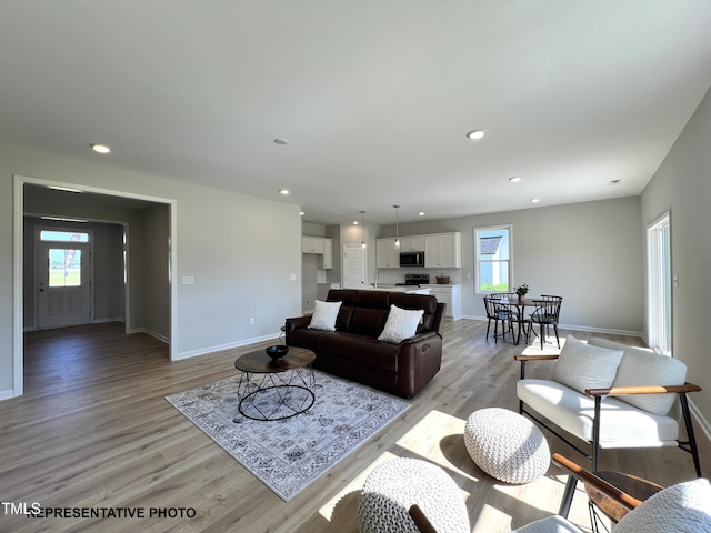 living room with baseboards, light wood-style floors, and recessed lighting