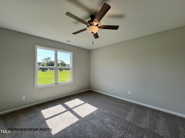 unfurnished room featuring dark colored carpet, ceiling fan, and baseboards