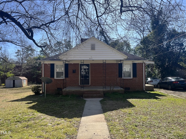 bungalow with an outdoor structure, a storage unit, brick siding, and covered porch