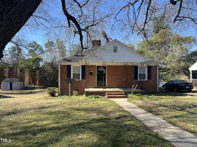 bungalow with a front yard, brick siding, covered porch, and a chimney