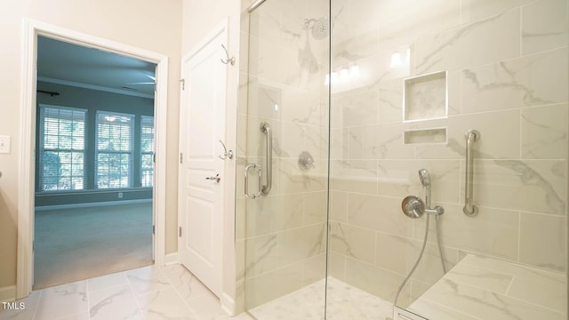 full bath featuring marble finish floor, a shower stall, baseboards, and ornamental molding