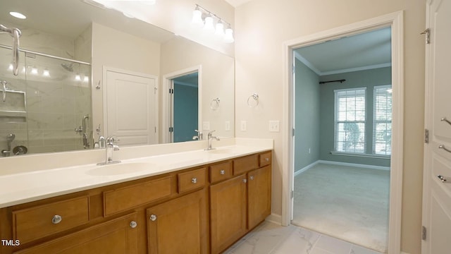 bathroom with double vanity, ornamental molding, a shower with door, and a sink