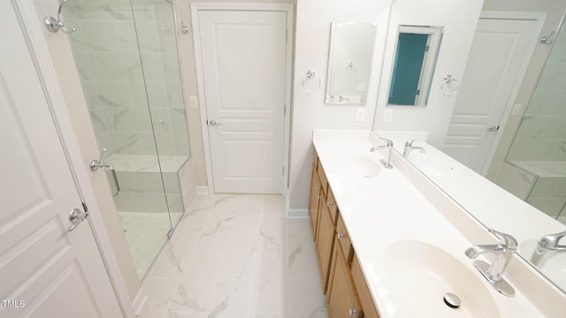 bathroom featuring a shower stall, double vanity, marble finish floor, and a sink