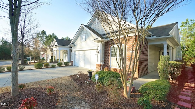 view of home's exterior with concrete driveway, an attached garage, and brick siding