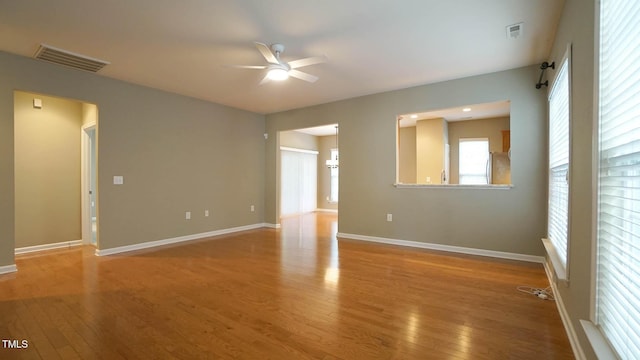 spare room with visible vents, baseboards, a ceiling fan, and wood-type flooring