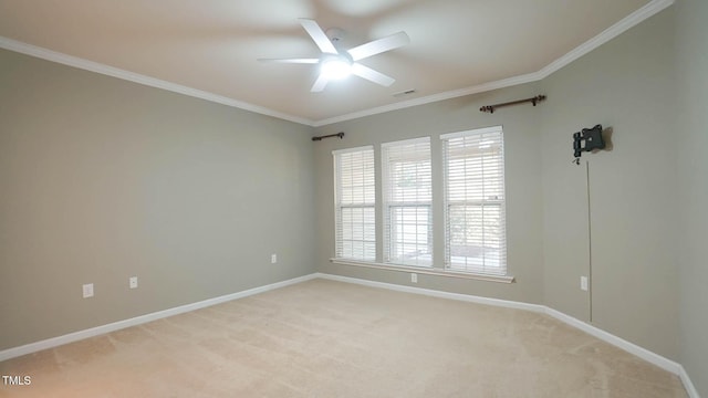 spare room with light colored carpet, a ceiling fan, baseboards, and ornamental molding