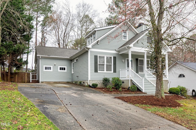 view of front of house with driveway, a shingled roof, a chimney, crawl space, and covered porch