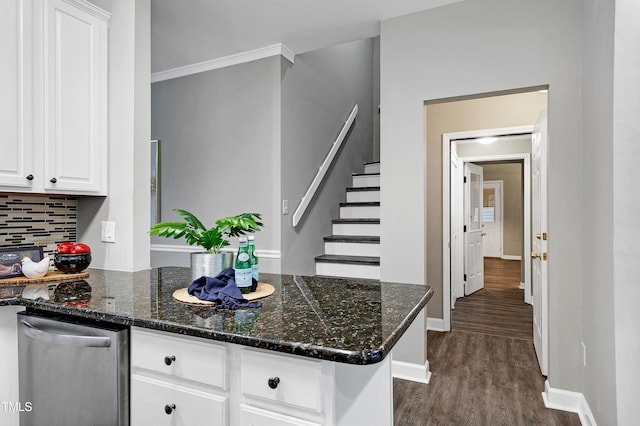 kitchen with a peninsula, dark wood-style flooring, decorative backsplash, and white cabinets