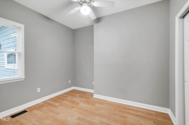 empty room with light wood-type flooring, baseboards, visible vents, and a ceiling fan