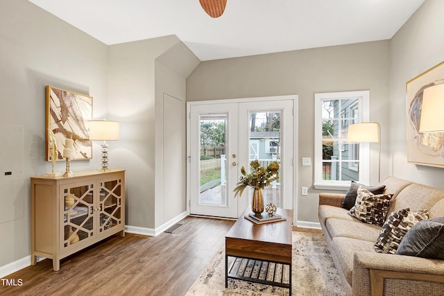 living area with french doors, baseboards, and wood finished floors