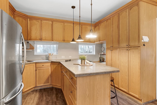 kitchen with a kitchen breakfast bar, dark wood-type flooring, freestanding refrigerator, a peninsula, and light countertops