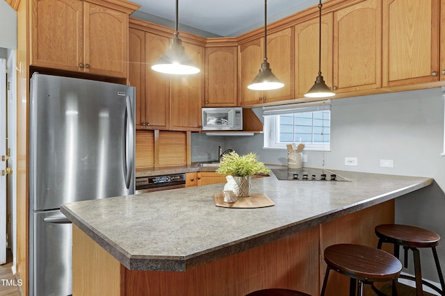 kitchen with stainless steel appliances, a breakfast bar, a peninsula, and pendant lighting