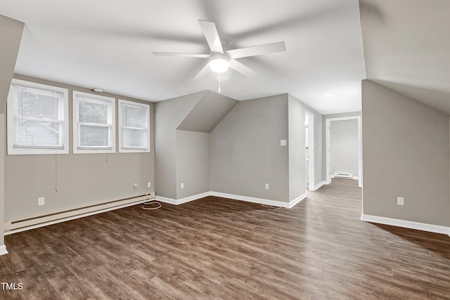 additional living space featuring wood finished floors, a ceiling fan, baseboards, vaulted ceiling, and baseboard heating