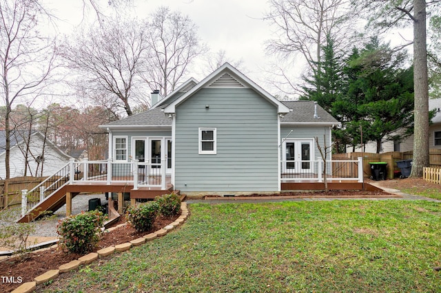 rear view of property featuring a deck, french doors, a lawn, and fence