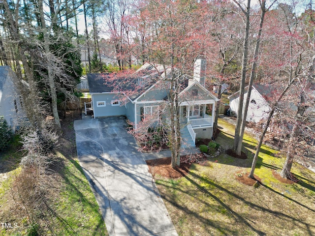 view of front of home featuring crawl space, covered porch, a front lawn, and concrete driveway