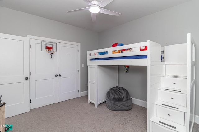 unfurnished bedroom with a ceiling fan, light carpet, and baseboards