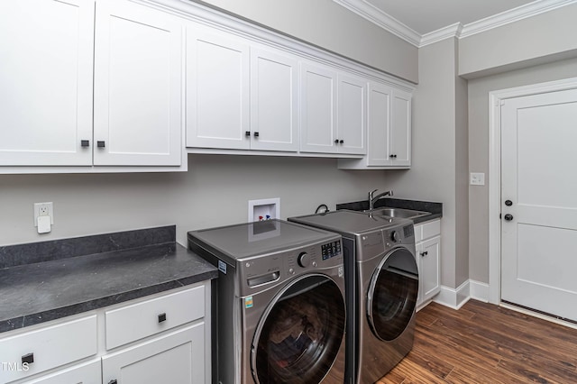 clothes washing area featuring cabinet space, ornamental molding, dark wood-style flooring, washing machine and clothes dryer, and a sink