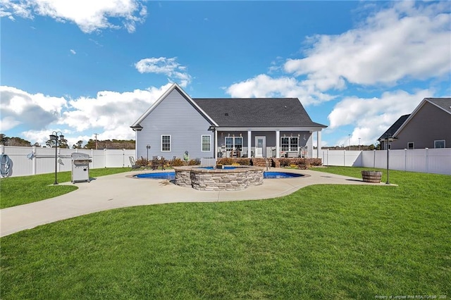 back of property featuring a fenced backyard, a fenced in pool, a patio, and a yard