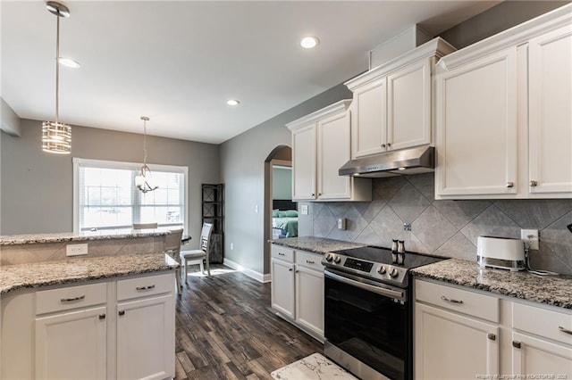 kitchen with under cabinet range hood, white cabinetry, stainless steel electric stove, and arched walkways