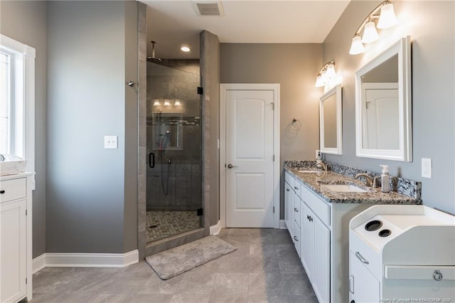 bathroom featuring a stall shower, baseboards, visible vents, and vanity