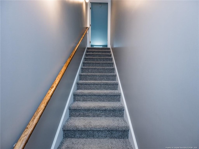 stairway with carpet floors and baseboards