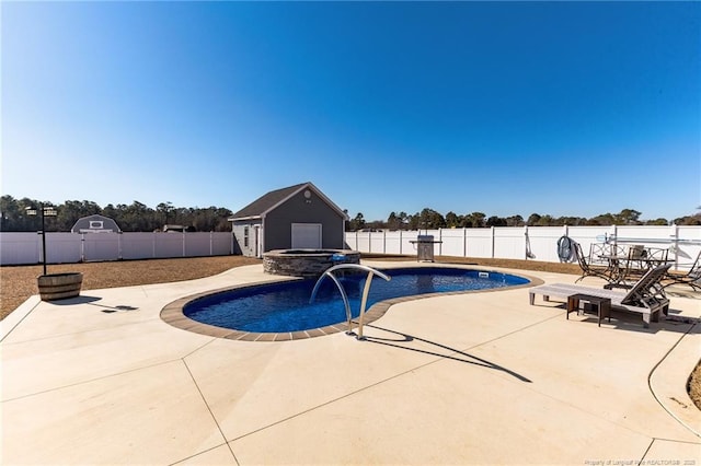 view of pool with an outbuilding, a pool with connected hot tub, a fenced backyard, and a patio