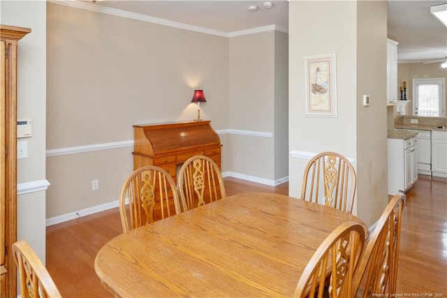 dining area with baseboards, ceiling fan, light wood finished floors, and crown molding