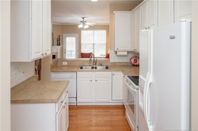 kitchen featuring white appliances, a ceiling fan, light countertops, white cabinetry, and a sink