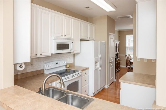 kitchen featuring white appliances, a sink, visible vents, and white cabinets