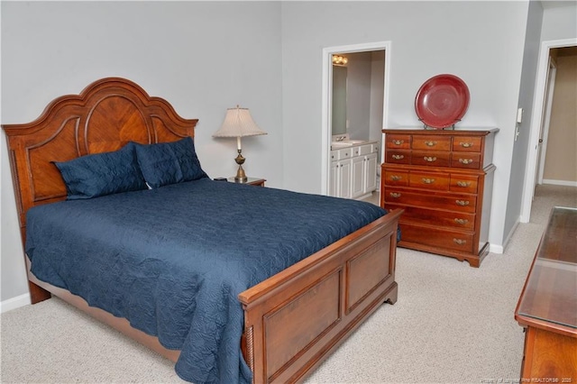 bedroom with light carpet, ensuite bath, and baseboards