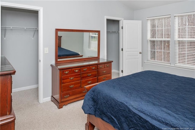 carpeted bedroom with lofted ceiling, a spacious closet, and baseboards