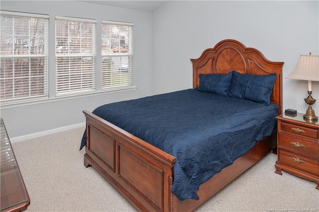 bedroom with light colored carpet and baseboards