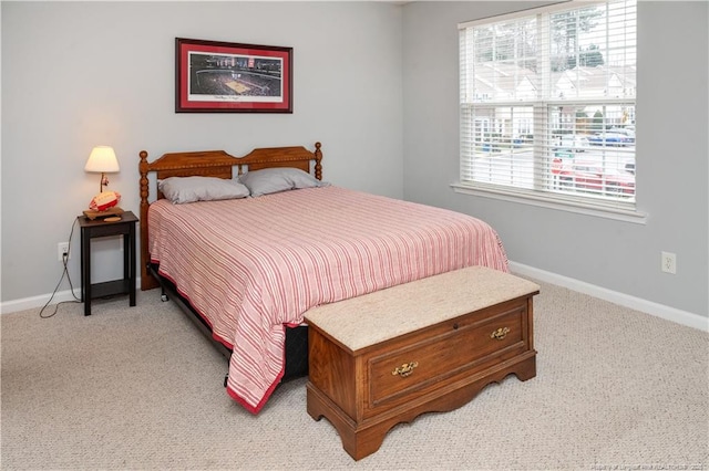 bedroom featuring light colored carpet and baseboards