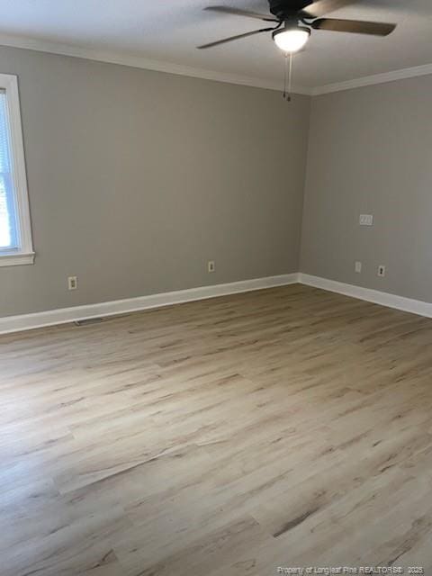 unfurnished room with ceiling fan, baseboards, crown molding, and wood finished floors