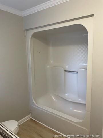 bathroom with ornamental molding, toilet, baseboards, and wood finished floors